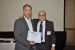 Dr. Nagib Callaos, General Chair, giving Prof. Detlev Doherr the best paper award certificate of the session "Informatics: Technologies and Applications." The title of the awarded paper is "Automatic Identification of Travel Locations in Rare Books - Object Oriented Information Management."